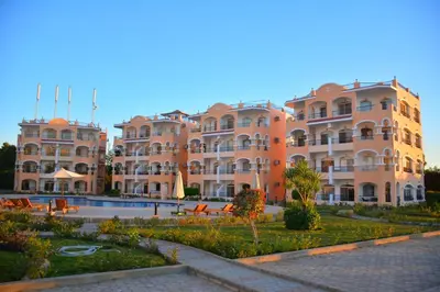 a large building with a pool in front of it at Aton Apartment, Luxor Resort, Minutes from City Center in Luxor