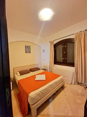 a bedroom with a bed with an orange blanket at bedroom in west golf 1 in El Gouna