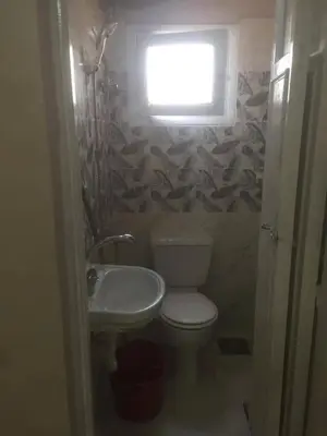a bathroom with a toilet and a sink and a window at اسوان كسر الحجر وسط البلد in Aswan