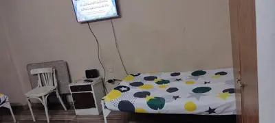a bedroom with a bed and a desk and a lamp at اسوان كسر الحجر وسط البلد in Aswan