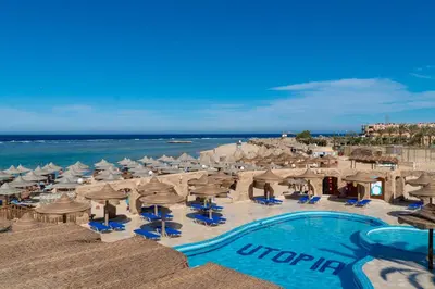 a beach with umbrellas and chairs and a swimming pool at UTOPIA Blue Resort in Quseir