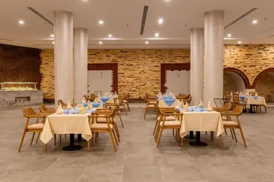 a restaurant with tables and chairs and a brick wall at UTOPIA Blue Resort in Quseir