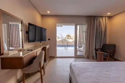 a hotel room with a bed and a television at UTOPIA Blue Resort in Quseir