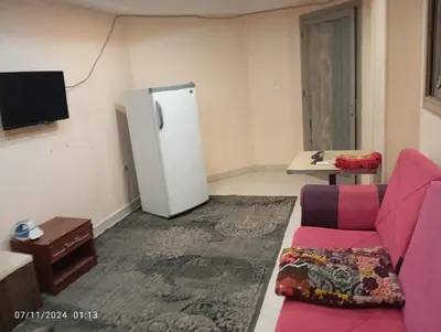 a living room with a couch and a refrigerator at شقة في موا بلازا كورنيش النيل اسوان Apartment in Mowa Plaza Aswan Nile Corniche in Aswān