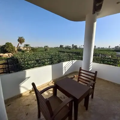 a table and chairs on a balcony with a view at Banana Guest House in Luxor