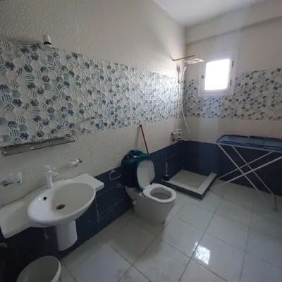 a blue and white bathroom with a toilet and a sink at Banana Guest House in Luxor