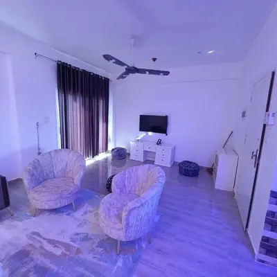 a living room with two chairs and a tv at Banana Guest House in Luxor