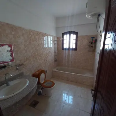 a bathroom with a toilet and a sink and a tub at Banana Guest House in Luxor
