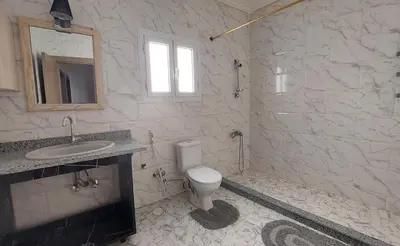 a white bathroom with a sink and a toilet at Hurghada Concierge at St Paul building 3 bd in Hurghada