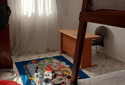a bedroom with a desk and a rug on the floor at Hurghada Concierge at St Paul building 3 bd in Hurghada