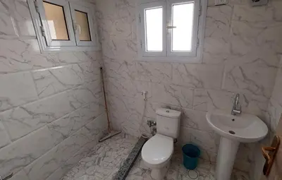 a white bathroom with a toilet and a sink at Hurghada Concierge at St Paul building 3 bd in Hurghada