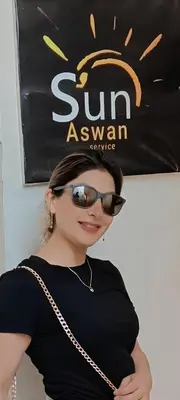 a woman wearing sunglasses standing in front of a sign at Sun Aswan inn in Aswan