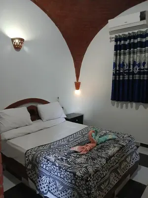 a doll laying on a bed in a bedroom at Nile Rose Hause in Al Karnak