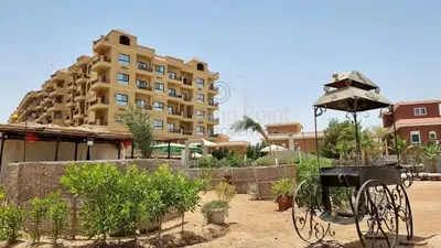 a view of a building with a grill and plants at Turtles beach resort ED Seaview Apartment in Hurghada