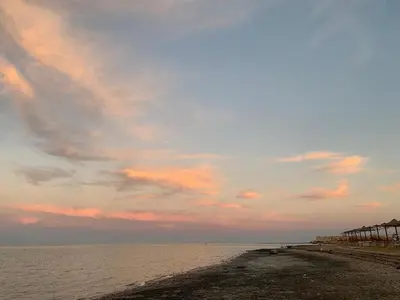 a beach with a cloudy sky and the ocean at Fanadir Bay Resort, rental chalet apartment in Hurghadana in Hurghada