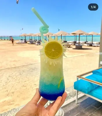 a person holding a drink with a margarita and a lemon slice at Fanadir Bay Resort, rental chalet apartment in Hurghadana in Hurghada