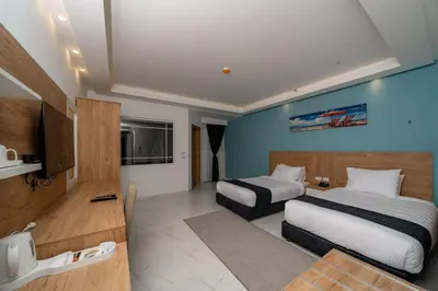 a hotel room with two beds and a tv at Sky Star Hotel free shuttle to Hurghada City Center in Hurghada