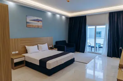 a hotel room with a bed and a blue chair at Sky Star Hotel free shuttle to Hurghada City Center in Hurghada