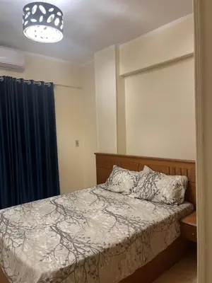 a bedroom with a bed and a blue curtain at Central Hurghada Apartment in Hurghada