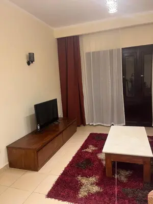 a living room with a flat screen tv on top of a table at Central Hurghada Apartment in Hurghada