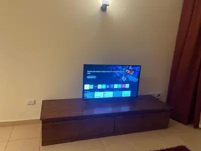 a flat screen tv sitting on top of a wooden table at Central Hurghada Apartment in Hurghada