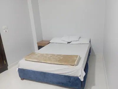 a bed in a white room with a blue mattress at فندق تيم وتميم in Luxor