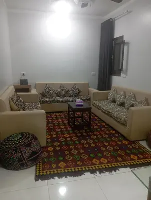 a living room with two couches and a rug at فندق تيم وتميم in Luxor