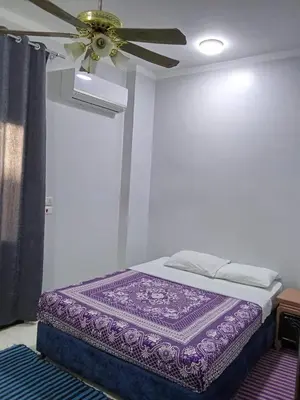 a bedroom with a ceiling fan and a purple mattress at فندق تيم وتميم in Luxor