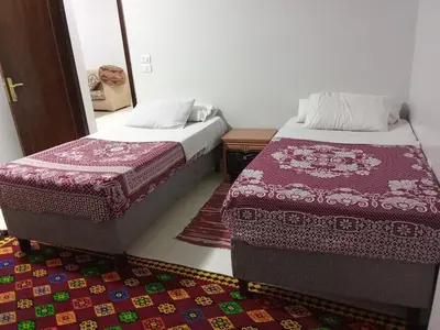 a bedroom with two beds and a rug at فندق تيم وتميم in Luxor
