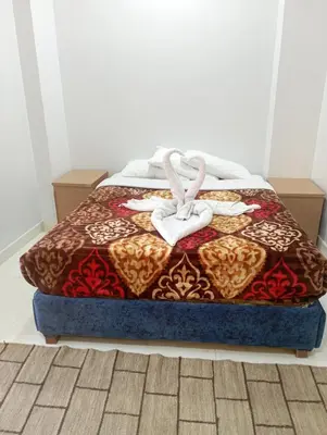 a bed with two white towels on top of it at فندق تيم وتميم in Luxor