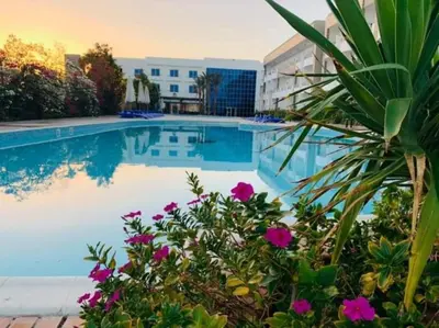 a swimming pool with purple flowers in front of a building at Elite apartment private beach Holiday Chalet Free WIFI in Hurghada