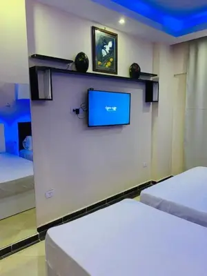 a room with two beds and a tv on a wall at Elite apartment private beach Holiday Chalet Free WIFI in Hurghada