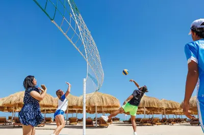 a group of people playing volleyball on the beach at Sunrise Alora Aqua Park Resort in Hurghada