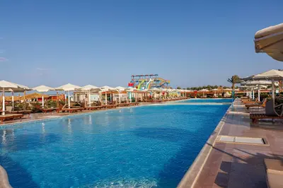 a pool at a resort with a roller coaster at Sunrise Alora Aqua Park Resort in Hurghada