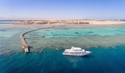 a boat in the water next to a bridge at Soma Breeze Sea and Golf view in Hurghada