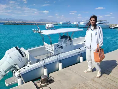 a woman standing on a dock next to a boat at Soma Breeze Sea and Golf view in Hurghada