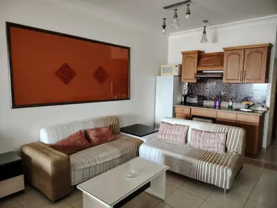 a living room with two couches and a kitchen at Studio for rent in the view 114 in Hurghada