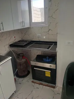 a kitchen with a stove top oven in a kitchen at white popular apartment in Al Karnak
