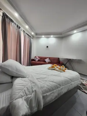 a bedroom with a large bed with a couch at Scandic Resort Hurghada in Hurghada