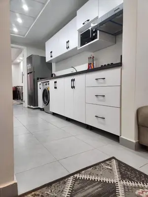 a kitchen with white cabinets and a washer and dryer at Scandic Resort Hurghada in Hurghada