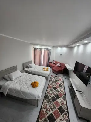 a bedroom with two beds and a flat screen tv at Scandic Resort Hurghada in Hurghada