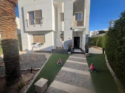 a house with three artificial grass in front of it at Sky star 130 in Hurghada