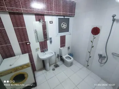 a bathroom with a toilet and a sink and a shower at SuperElite apartment NileView F4 in Naj‘ al ‘Amrāb