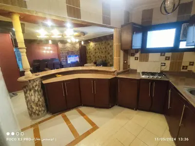 an empty kitchen with wooden cabinets in a room at SuperElite apartment NileView F4 in Naj‘ al ‘Amrāb