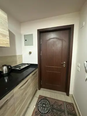a kitchen with a wooden door and a counter top at Aldau heights 2 in Hurghada