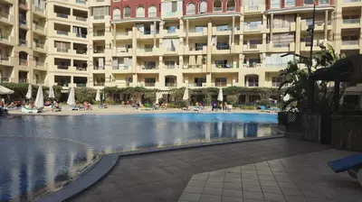 a swimming pool in front of a large building at Dive Hostel Hurghada Pool in Hurghada