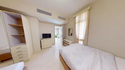 a white bedroom with a bed and a tv at 2bedroom in mangrove in gouna in Hurghada