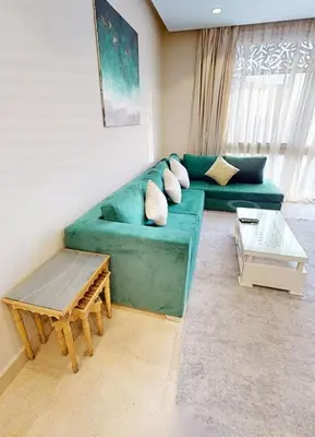 a living room with a green couch and a table at 2bedroom in mangrove in gouna in Hurghada