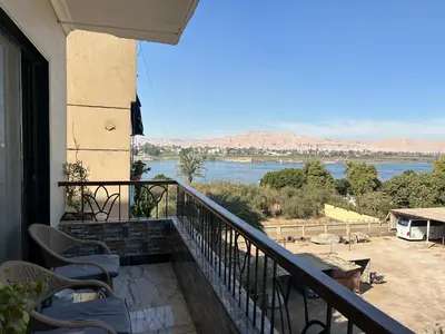 a balcony with chairs and a view of the water at Oscar Apartment 9 in Luxor