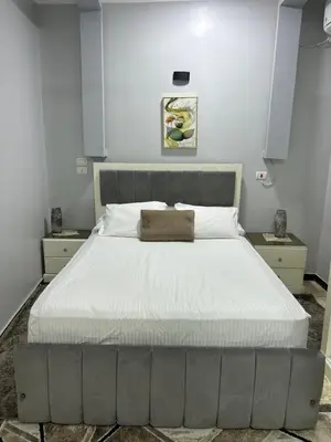 a bedroom with a large bed with white sheets at Oscar Apartment 9 in Luxor